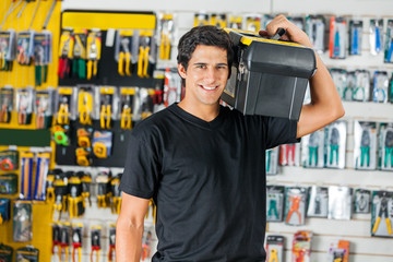 Smiling Man Carrying Toolbox On Shoulder In Store