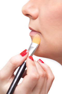 Detail of the face of a girl with a brush for makeup