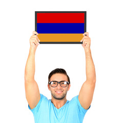Portrait of a young casual man holding up board with National fl