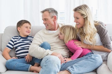 Smiling family sitting on sofa