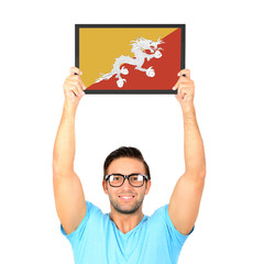 Portrait of a young casual man holding up board with National fl