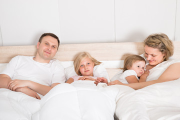 Obraz premium Young Family Lying Together In Bed