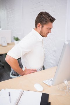 Businessman suffering from backache in office