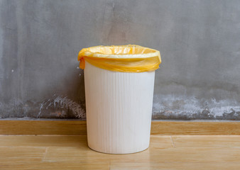 The white plastic bin with orange bag on wooden floor with expos