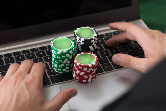Businessman Using Laptop With Stacked Poker Chips