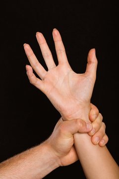 Male hand grabbing female wrist