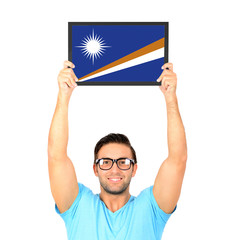 Portrait of a young casual man holding up board with National fl