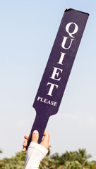 The quiet please sign was held up by staff in golf tournament.