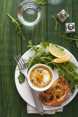 Baked egg with salad and bread