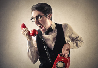 Angry man speaking on the phone - obrazy, fototapety, plakaty