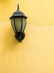 Vintage style lamp on rustic yellow wall