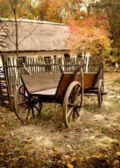 Fototapeta na wymiar Vintage wooden cart in the yard in the autumn