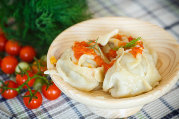 large boiled manti in the wooden saucer