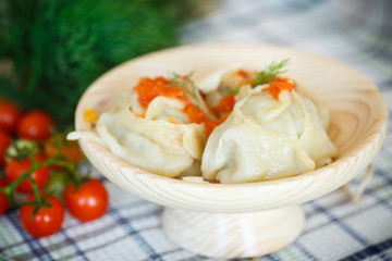 large boiled manti in the wooden saucer