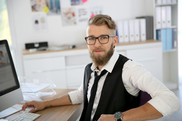 Young man with beard and eyeglasses in office