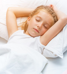 Fototapeta premium little girl sleeping in white bed