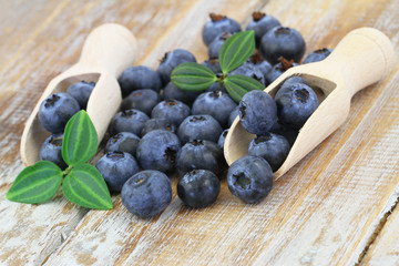Blueberries on wooden scoops on wooden surface