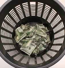 Money in basket. Dollars in the trash bin