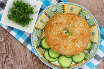 Bagel with cream cheese, cucumber and watercress, close up