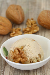 Walnut ice cream scoop in porcelain bowl