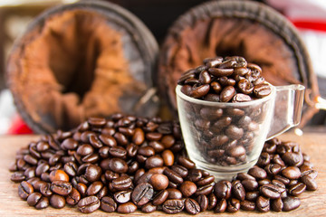 Coffee beans in glass on old wood, which lay near the filter