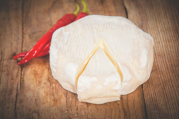 Smelly blue cheese on a wooden rustic table with hot chili peppe