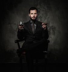 Handsome well-dressed with glass of beverage and cigar