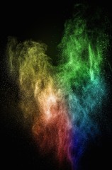 Colourful powder exploding isolated on black
