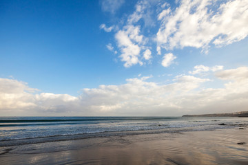 Atlantic ocean coast with bright blue cloudy sky