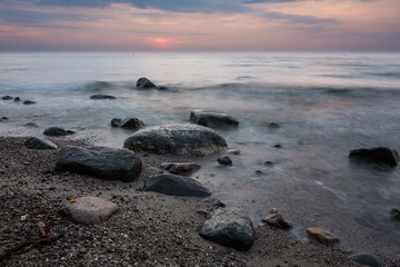Fototapeta na wymiar Baltic sea at beautiful sunrise on beach. big rocks in the water