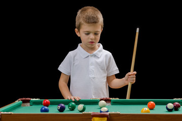 Fototapeta premium Beautiful boy playing billiard (pool)