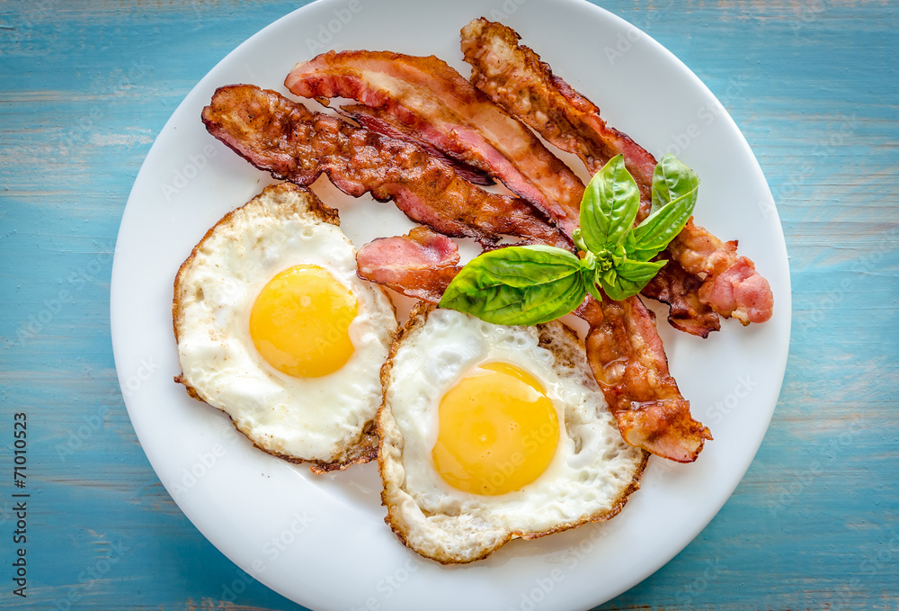 Sticker fried eggs with bacon on the wooden table