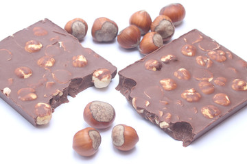 Chocolate bar with hazelnuts on white background