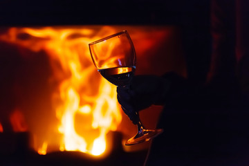 Obraz na płótnie Canvas glass of wine beside the fire