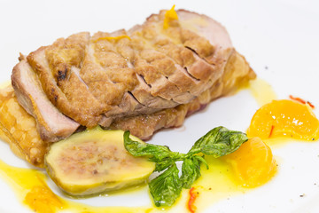 goose breast with vegetables on a white plate