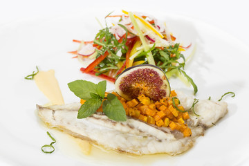 Baked fish with salad on a white background in restaurant