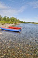 Two inflatable canoes on the shore of  North river.