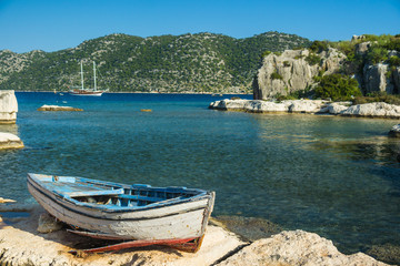 An old fishing boat moored at Simena peninsula with an ancient i