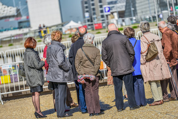 A large group of elderly tourists listening to the guide