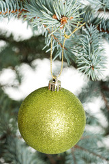 One separated christmas ball handing on a twig.