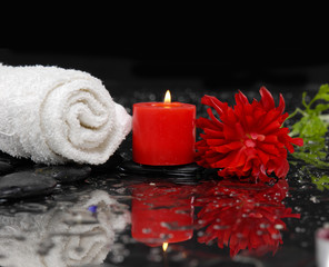 Fototapeta na wymiar Red ranunculus flower with towel and candle and therapy stones
