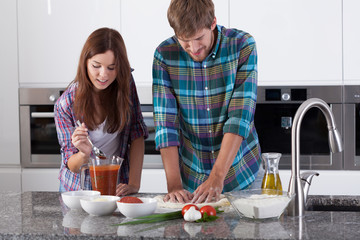 Couple making pizza at home
