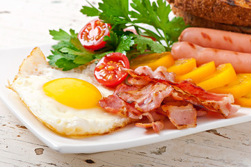 English breakfast - fried eggs, bacon, sausages and toasted 