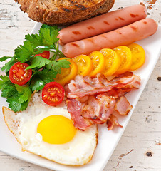 English breakfast - fried eggs, bacon, sausages and toasted 