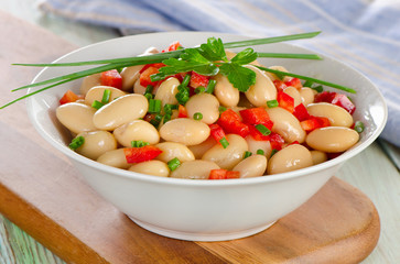 White bean salad   on a wooden board.