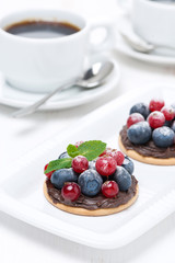 mini cakes with chocolate cream and berries and coffee