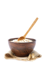 Oatmeal flakes in bowl on white background. Healthy food.