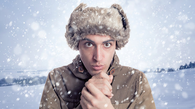 Portrait of young man with eskimo hat and winter  background wit