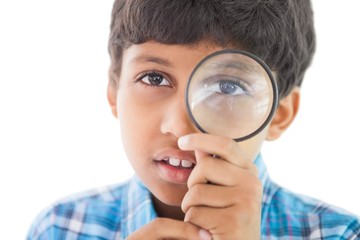 Cute boy looking through a magnifying glass