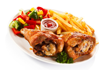 Grilled turkey legs with French fries and vegetables